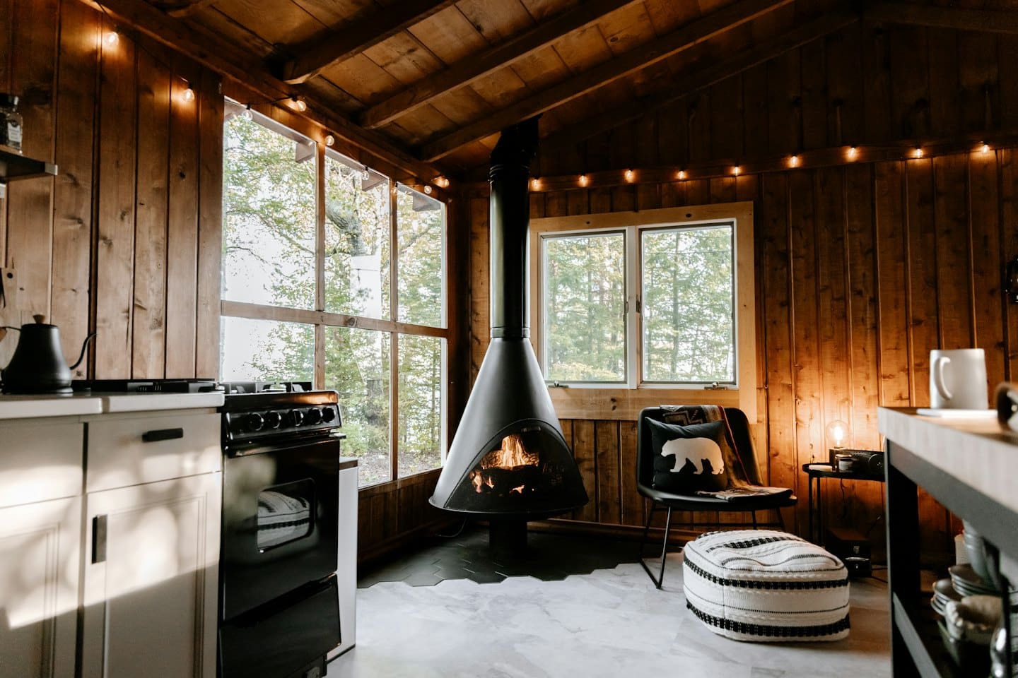 Rustic cabin interior with fireplace and scenic window views.